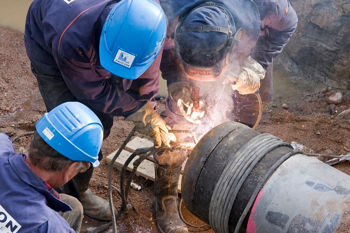 Crew welding a pipeline joint on a right-of-way